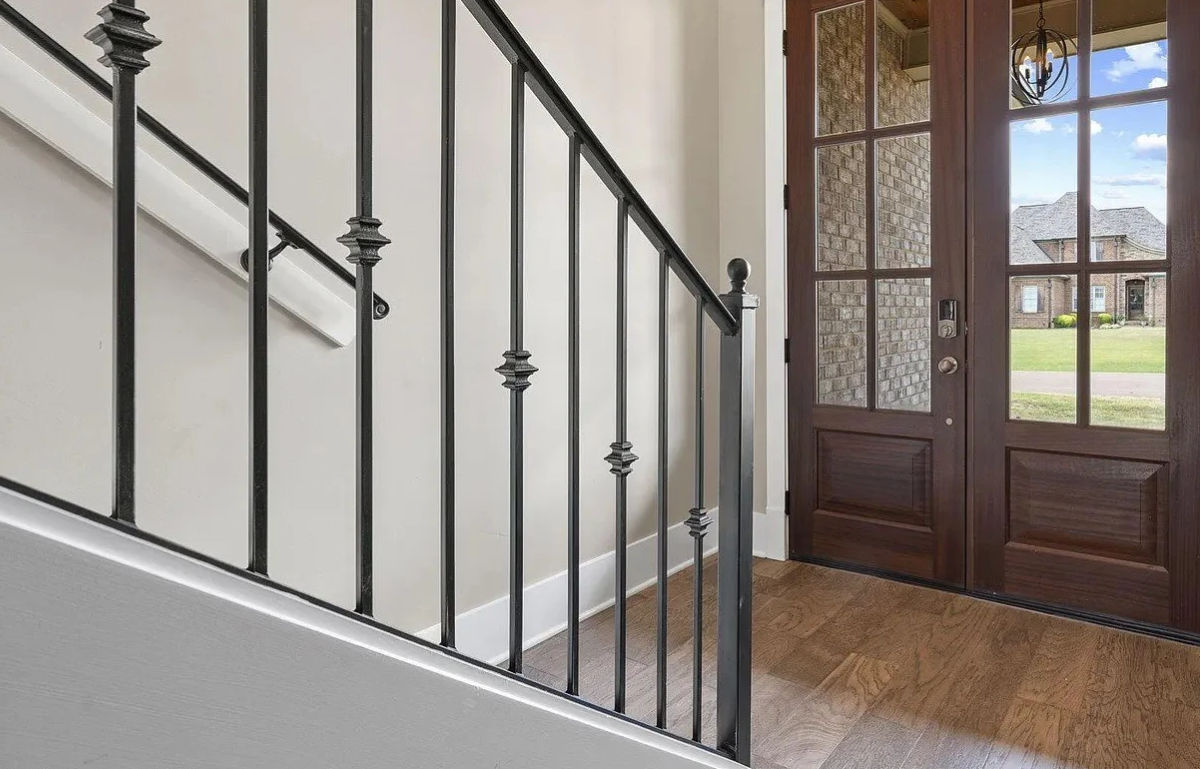 Modern entry with oak doors and iron staircase.